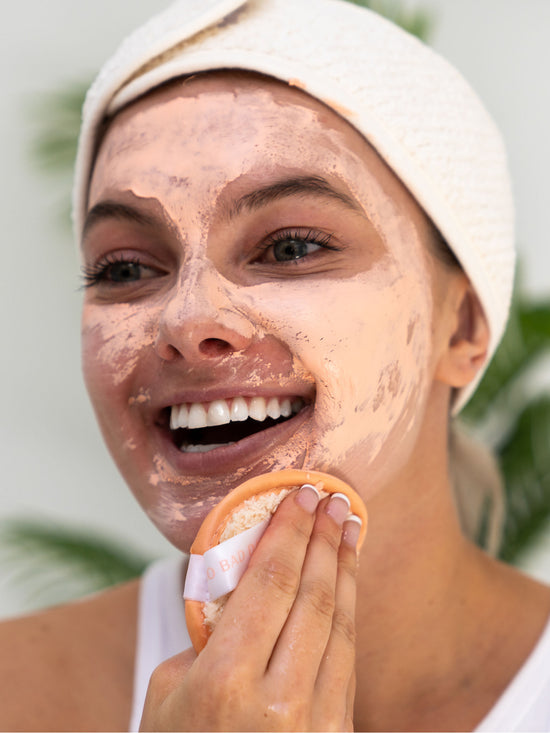 girl removing clay mask with remover pad